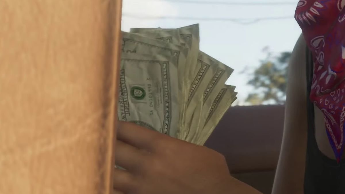 A close-up shot of a woman’s hand holding a stack of crumpled $20 bills.